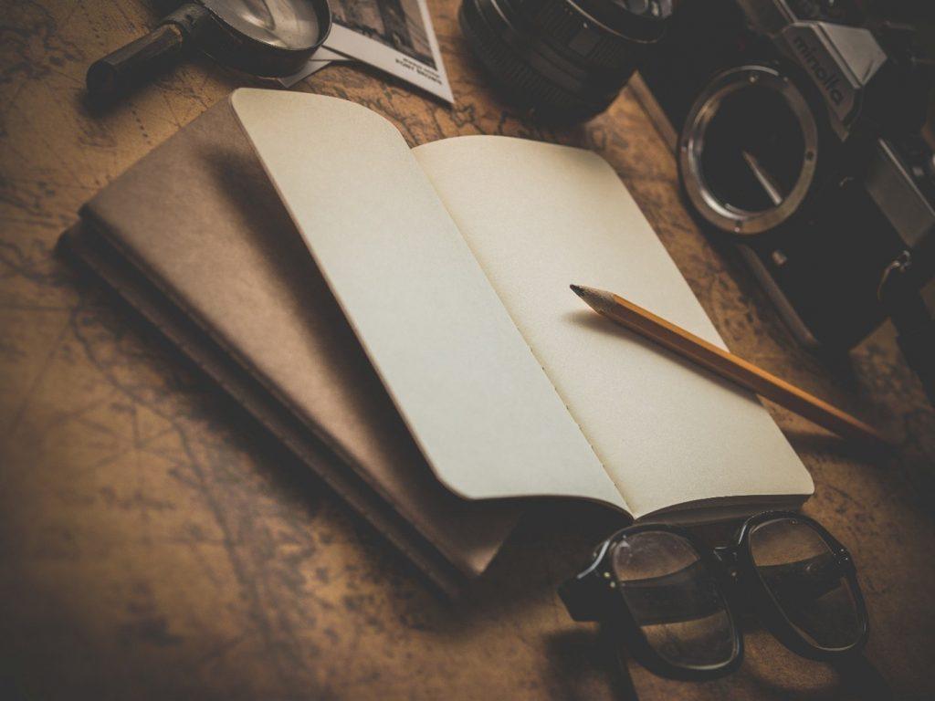 carnet de gratitude et tasse d’infusion sur une table en bois.