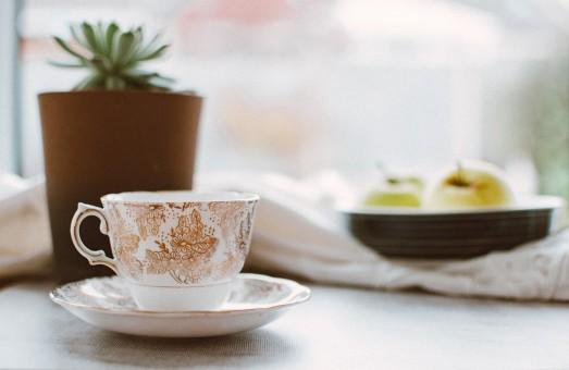 chambre tamisée, tasse de tisane sur table de chevet.