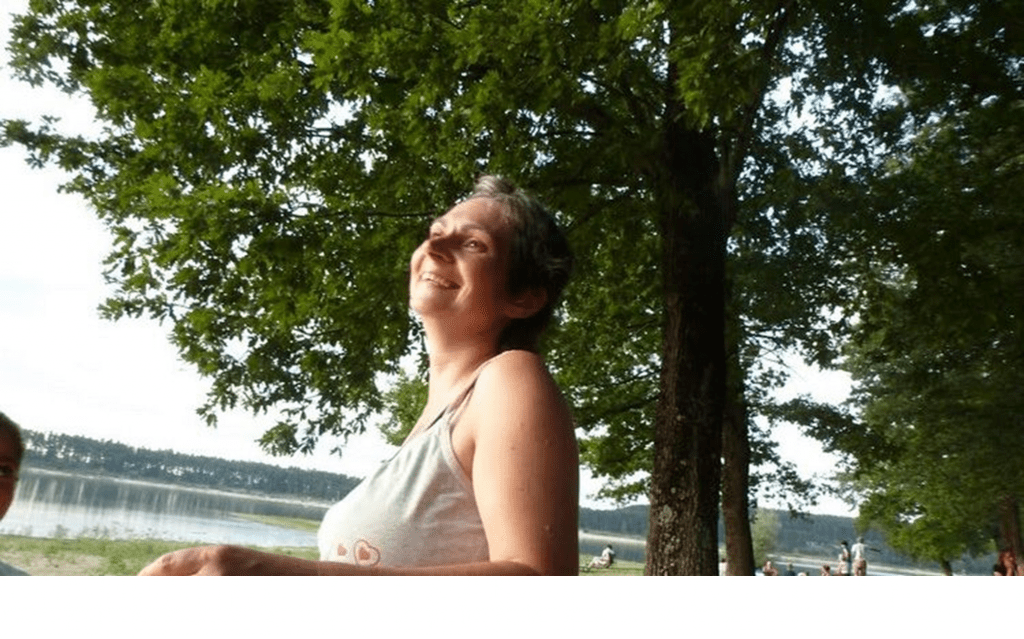 femme assise près d’une fenêtre, regard tourné vers la lumière, atmosphère calme et naturelle.