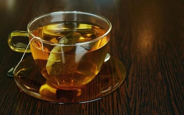 lit avec tasse de tisane, lumière douce, ambiance nocturne paisible.