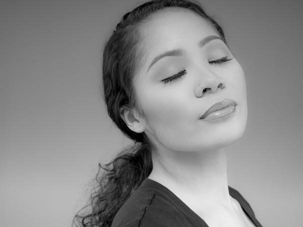 visage serein, yeux fermés, ambiance douce et apaisante.